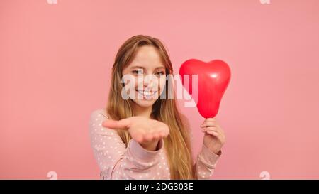 Portrait of young woman holding heart balloon and sending kisses. Valentines day, love and romance concept. High quality photo Stock Photo