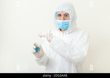 Covid19 vaccine in doctors hands. Doctor in protective medical suit, biological hazard, medical mask gloves on white background. Coronavirus vaccine Stock Photo