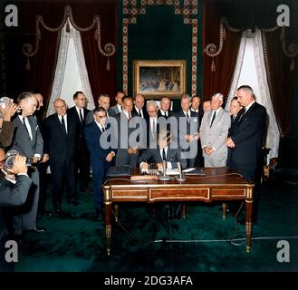 United States President John F. Kennedy signs the Limited Nuclear Test Ban Treaty in the White House Treaty Room on October 7, 1963. From left to right: William Hopkins, U.S. Senator Mike Mansfield (Democrat of Montana), John J. McCloy, Adrian S. Fisher, U.S. Senator John Pastore (Democrat of Rhode Island), W. Averell Harriman, U.S. Senator George Smathers (Democrat of Florida), U.S. Senator J.W. Fulbright (Democrat of Arkansas), U.S. Secretary of State Dean Rusk, U.S. Senator George Aiken (Republican of Vermont), President Kennedy, U.S. Senator Hubert H. Humphrey (Democrat of Minnesota), U.S. Stock Photo