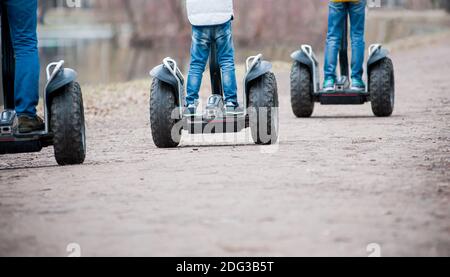 People riding segway - personal self-balancing transporters in autumn park Stock Photo