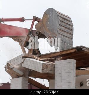 Wreck excavator at work demolishing a building wall Stock Photo
