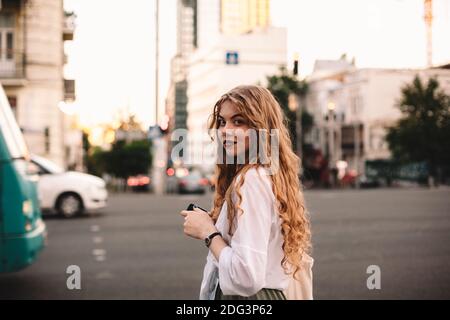 Portrait of serious young woman standing on street in city Stock Photo