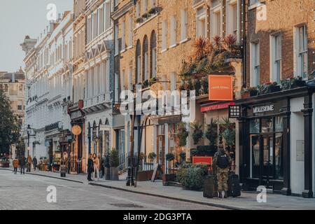 London, UK - November 19, 2019: Row of shops on a street in Covent Garden, a famous tourist area in London with lots of shops and restaurants, few peo Stock Photo