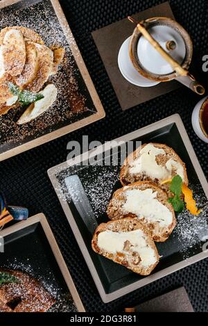 various desserts with tea on a black background Stock Photo