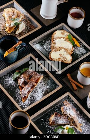 various desserts with tea on a black background Stock Photo