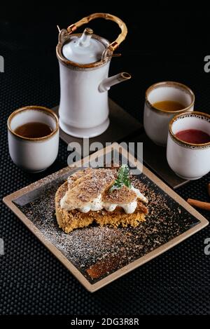 various desserts with tea on a black background Stock Photo
