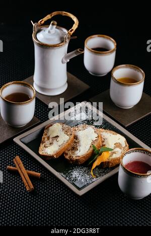 various desserts with tea on a black background Stock Photo