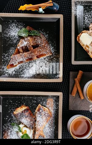 various desserts with tea on a black background Stock Photo