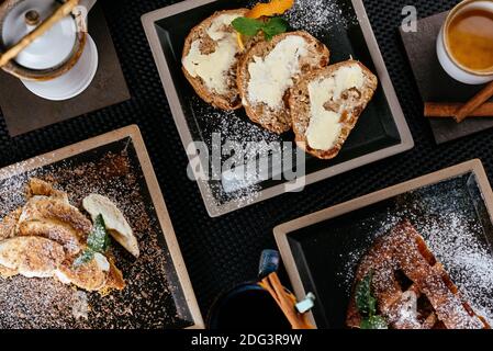 various desserts with tea on a black background Stock Photo