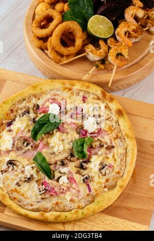 Italian pizza and beer snacks on a wooden Board and light background Stock Photo