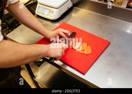 men's hands butchering fish in the kitchen Stock Photo