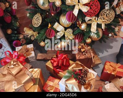 Bright present boxes under a decorated Christmas tree Stock Photo