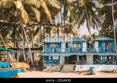 Canacona, Goa, India. Famous Painted Guest Houses On Palolem Beach Against Background Of Tall Palm Trees In Sunny Day