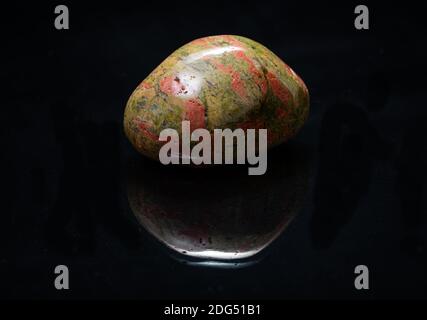 Highly polished puffy Unakite specimen from Unakas Mountains in North Carolina, on black background. Stock Photo