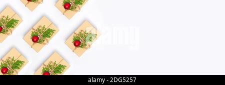 Banner with christmas handmade presents pattern decorated with craft paper, branch and ball on white background. Flay lay, top view with copy space Stock Photo