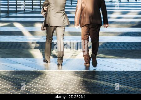 Two businessmen walking in an office park Stock Photo