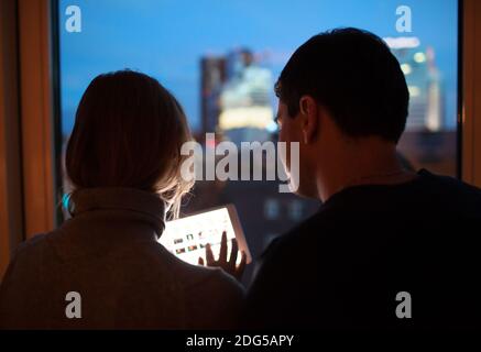 Couple Using Tablet PC in the Evening Stock Photo