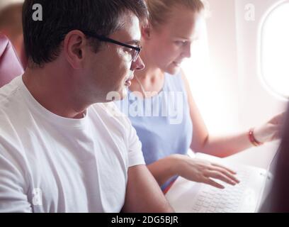 People with Laptop on a Plane Stock Photo