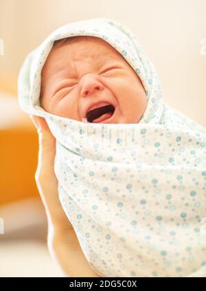 Crying newborn in mothers hands Stock Photo
