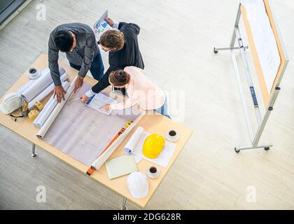 Top view of Caucasian engineer group teamwork meeting for planning project on the table with paperwork. Corporation creativity people. Stock Photo