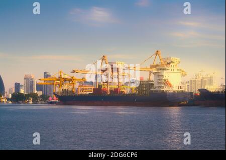 International Container Cargo ship with working crane bridge in shipyard background, logistic import export background and transport industry. Stock Photo