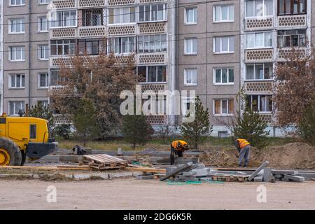 RUSSIA, ANGARSK - October 19, 2020 Construction, repair of a road in a residential area of the city. Workers and road construction equipment. Stock Photo