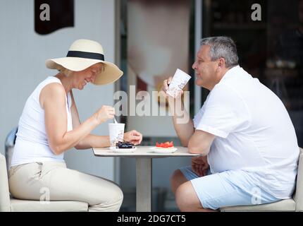 Couple Enjoying Coffee and Desserts on Cafe Patio Stock Photo