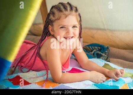 Happy smiling little girl with accessories in hair. Kids fashion. Stylish girl child with funny face. Kid casual style. Fashion model and beauty look. Stock Photo