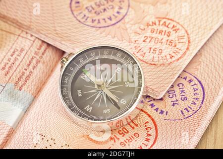On the page of passports with visas lies with the compass Stock Photo