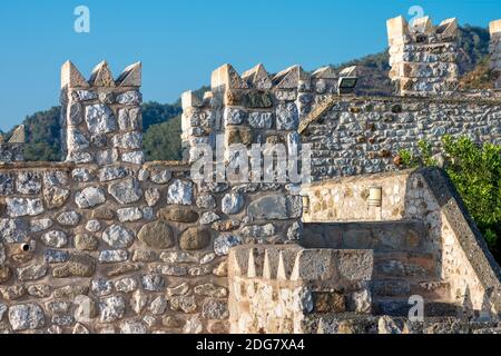 part of the medieval Fort in Marmaris Turkey. the walls and towers are made of large rough stone blocks. historic, heritage background. blue sky Stock Photo