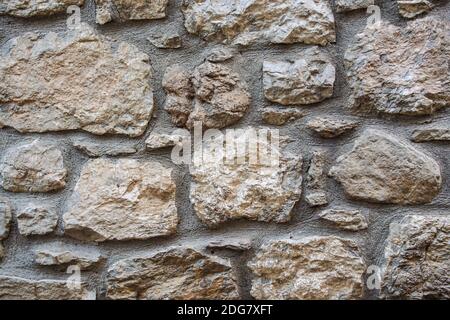 Stone wall of large stones. Rustic grey stone wall texture. part of a stone wall, for background or texture. close-up Stock Photo