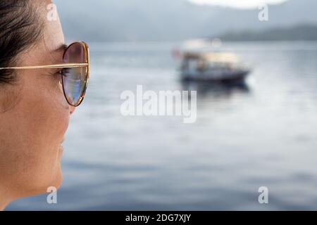 Middle-aged woman's face looks at the sea sitting on sea beach, traveling happy resting female looks at sea. concept of a holiday at the sea Stock Photo
