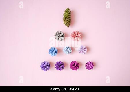 Christmas tree from Multi-colored pine cones on pink background, top view. Christmas and new year concept. Flat lay style. Stock Photo