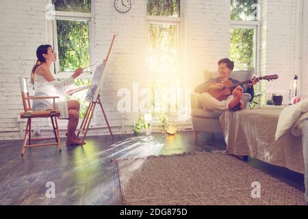 Happy young couples guitar drawing at home Stock Photo