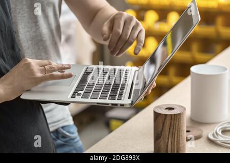 Couple using laptop in workshop Stock Photo