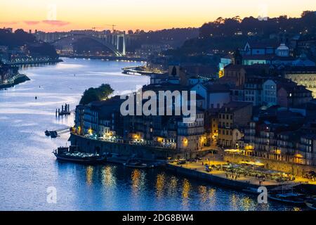 Elevated wide shot of Bairro da Ribeira in Porto during a beautiful twilight. The Ponte Arrabida is in the background Stock Photo