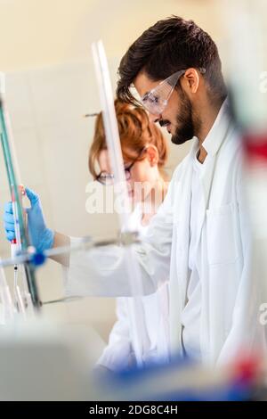 Group of medical research scientists collectively working in laboratory Stock Photo