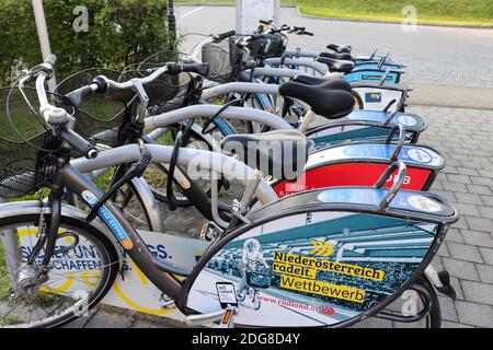 Rental bicycles locked up at a station near the Danube river in Austria on a spring day. Stock Photo