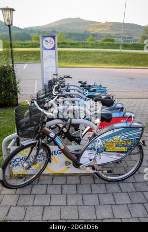 Nextbike rental bicycles locked up at a station in a town along the Danube river in Austria on a spring day. Stock Photo