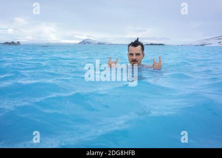 Guy relaxing in geothermal pool outdoors Stock Photo