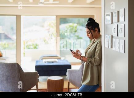 Woman using smart phone by home automation controls Stock Photo