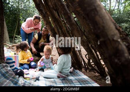 Happy family playing tea party in tree fort in woods Stock Photo