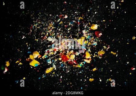 sugar candies falling from glass container on black table background. Empty space for text Stock Photo