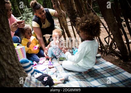 Family playing tea party in tree fort Stock Photo