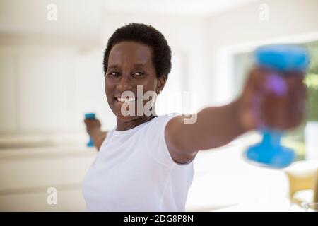Confident senior woman exercising with dumbbells Stock Photo