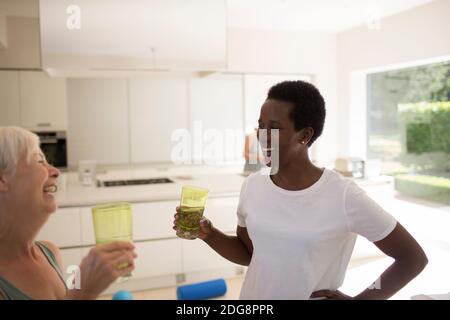 Happy senior women friends drinking water after exercising at home Stock Photo