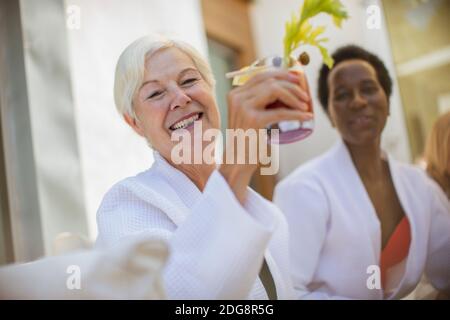 Happy senior women friends drinking cocktail on hotel patio Stock Photo