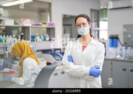 Portrait confident female scientist in face mask and rubber gloves Stock Photo