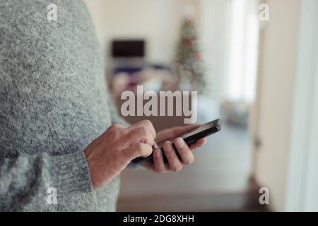 Close up man in sweater using smart phone Stock Photo
