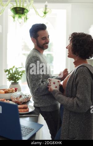 Happy couple talking and drinking coffee in morning kitchen Stock Photo